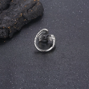 Detailed shot of silver punk style irregular snake ring on textured stone background