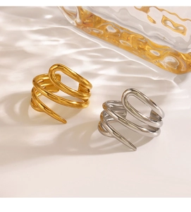 Detail of layered spiral open rings in gold and silver finish with elegant water shadow