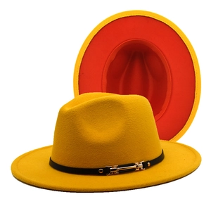 Detail of yellow fedora hat with red lining, black leather band, and gold buckle
