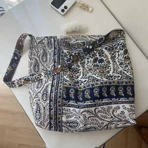 Detail of bohemian paisley print on a large capacity cotton linen crossbody tote bag
