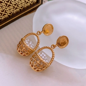 Detailed macro shot of vintage gold basket earrings with multiple faux pearls