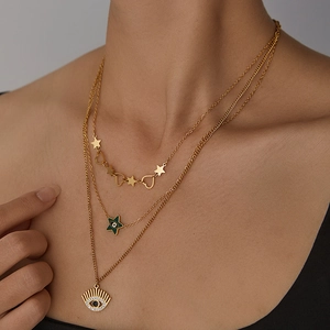 Collier à trois rangs en titane doré avec breloques étoile, cœur et œil grec sur un modèle