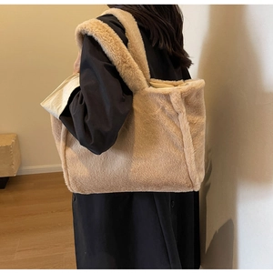 Détail d'un mannequin portant un grand sac cabas en peluche beige avec tissu vintage