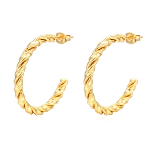 Detail view of gold-plated twisted rope C-shaped hoop earrings with textured finish