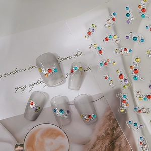 Colorful rhinestone nail stickers with silver metal base on translucent grey nails