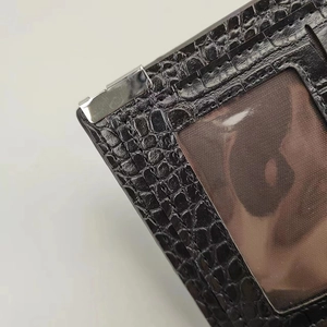 Detail view of black crocodile texture wallet featuring silver metal corners and photo slot