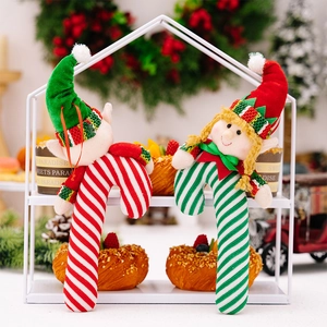 Christmas elf plush candy cane ornaments with red, white and green stripes in a festive setup