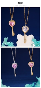 Detailed view of silver and gold heart key pendants with sparkling zircon on blue background