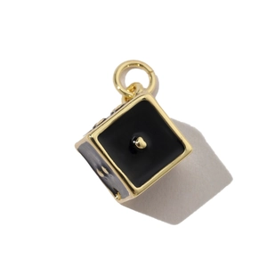 Detail of black enamel cube pendant with golden frame and hanging loop for DIY jewelry