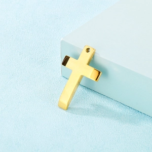 Polished gold stainless steel cross pendant on a textured light blue background