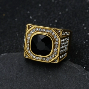 Macro view of gold signet ring with octagonal black gemstone and pavé diamonds