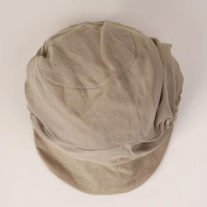 Detailed top view of beige linen baker boy hat showing textured fabric and pleats