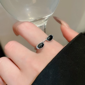 Macro shot of creative sunglasses style ring in silver finish with black enamel lenses