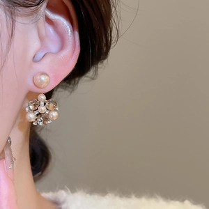 Dettaglio di eleganti orecchini con perle e cristalli indossati per uno stile vintage francese