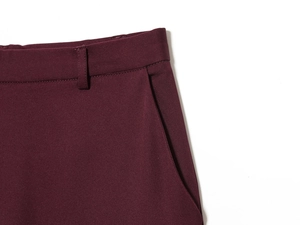 Detail of burgundy suit trousers showing waistline stitching and slanted side pockets