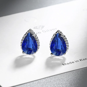 Close-up of teardrop dark blue zircon earring with silver beaded edge on a display card