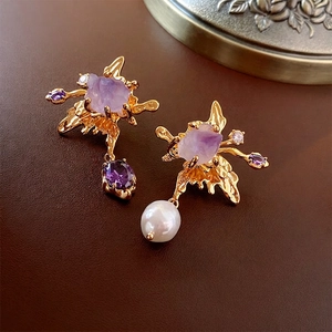 Asymmetric golden earrings with purple rhinestones and white pearls on leather