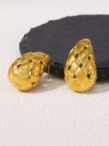 Detail shot of gold woven teardrop earrings with zircon inlay on black rock