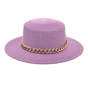 Détail d'un chapeau de paille violet à toit plat avec une chaîne décorative en acrylique doré
