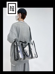 Close-up of clear PVC tote bag with black nylon trim showing high capacity and durability
