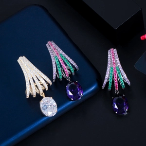 Detail of brass earrings with colorful zircons in fan-shaped design and oval gemstones