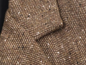 Gros plan sur la texture du tissu tweed marron à chevrons en mélange de laine premium