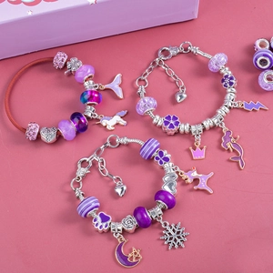 Detail of purple DIY bracelets featuring unicorn, mermaid, and crown pendants for girls