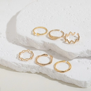 Detailed view of 6-piece gold ring set featuring star, heart, and feather designs on stone