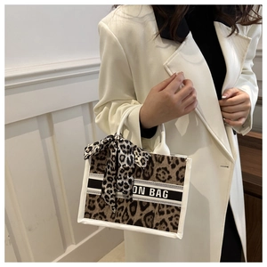 Detail of leopard print tote bag with ON BAG lettering and matching silk scarf handle