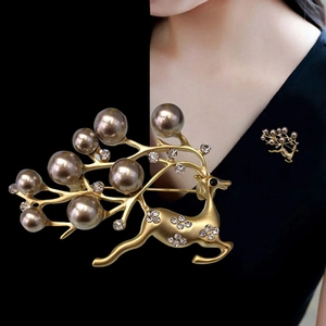 Detail of golden reindeer brooch with grey pearls and rhinestones on a blazer