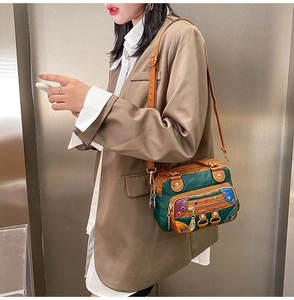 Detail of soft washed leather handbag with colorful rivets and contrast stitching