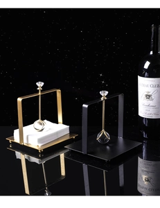 Detailed close-up of a stainless steel napkin holder with a large crystal topper on top