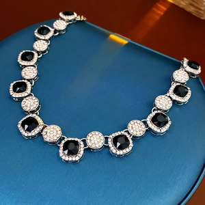 Détail du collier argenté avec pierres carrées noires et cristaux blancs pavés
