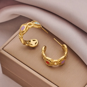 Gold stainless steel hoop earrings with colorful enamel eye charms on purple satin