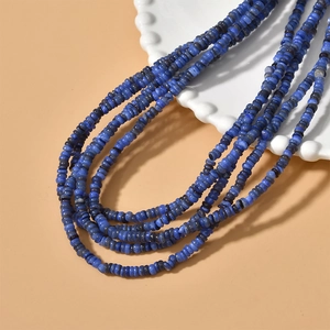Detailed view of 4mm blue freshwater shell disc beads for handmade jewelry on a ceramic plate