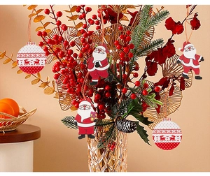 Close-up of wooden Christmas gnome and reindeer ornaments hanging on pine branches