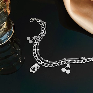 Double-layer stainless steel bracelet featuring cherry and owl charms on black mirror background