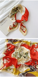 Detail of red and cream floral silk scarf tied elegantly next to an art book background