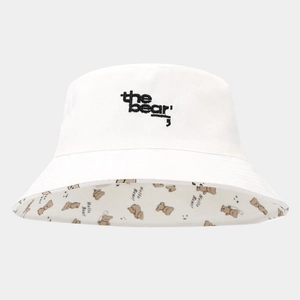 Detail of white canvas bucket hat featuring bear embroidery and printed cartoon inner brim