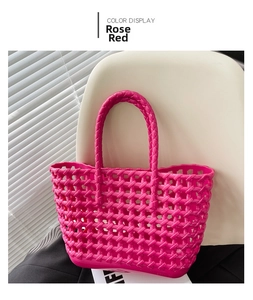 Detail of rose red woven tote bag featuring an open-work lattice and integrated handle