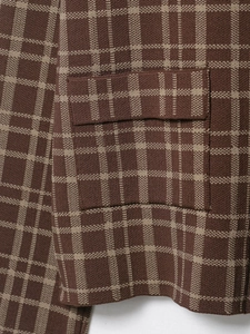 Makroaufnahme von braunem Strickkaromuster mit Textur und Taschenklappendetails