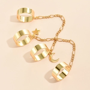 Detail view of golden multi-finger rings with star and crescent charms on a fine chain