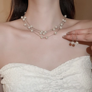 Elegant triple-strand pearl necklace and matching earrings set worn by a model