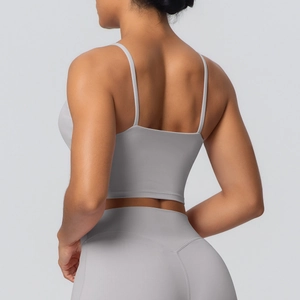 Détail des bretelles croisées sur un haut de yoga gris clair et un legging