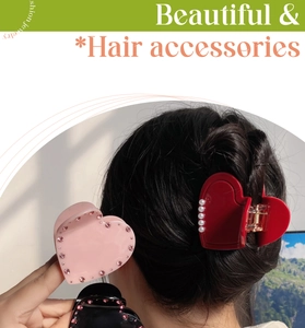 Detail of red acetate heart hair claw with pearls on braided hair accessories