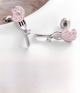 Macro detail of donut and fork cartilage stud earrings with pink oil drop and cubic zirconia