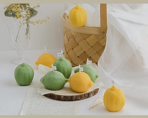 Detailed shot of realistic lemon and lime scented candles on a rustic wooden base