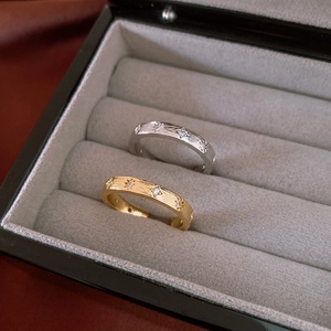Close-up of gold and silver brushed metal star rings with zircon in a jewelry box