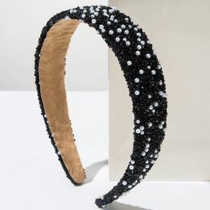 Close-up of wide headband with black crystals and white pearls on soft velvet lining
