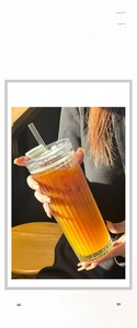 Detailed view of large glass coffee cup with vertical stripes and reusable straw